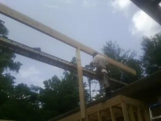 Carpenter setting a ridge beam over a new addition frame — Ice Dam Removal by Roofing Brothers in Saint Clair Shores
