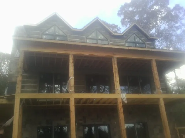 Dormers and porch framing on a large log home under construction — Roof Coating work by our crew in Saint Clair Shores